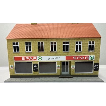 Byhus med Spar købmand. 2 etager gule sten. 